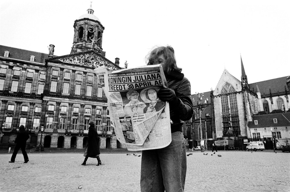 Aftreden_Koningin_Juliana_meisje_leest_ochtendkrant_met_grote_kop_op_de_Dam,_l,_Bestanddeelnr_930-6515