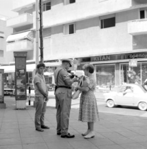 Agent_schrijft_een_bon_uit_op_de_stoep_in_een_winkelstraat_terwijl_de_persoon_di,_Bestanddeelnr_255-2008
