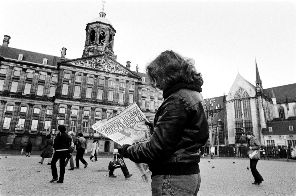 Aftreden_Koningin_Juliana_meisje_leest_ochtendkrant_met_grote_kop_op_de_Dam,_l,_Bestanddeelnr_930-6517