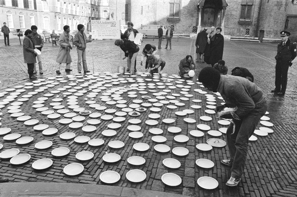 Actie_voor_aandacht_voedselhulp_Eritrea_bordjes_met_eten_op_het_Binnenhof,_Bestanddeelnr_933-2199