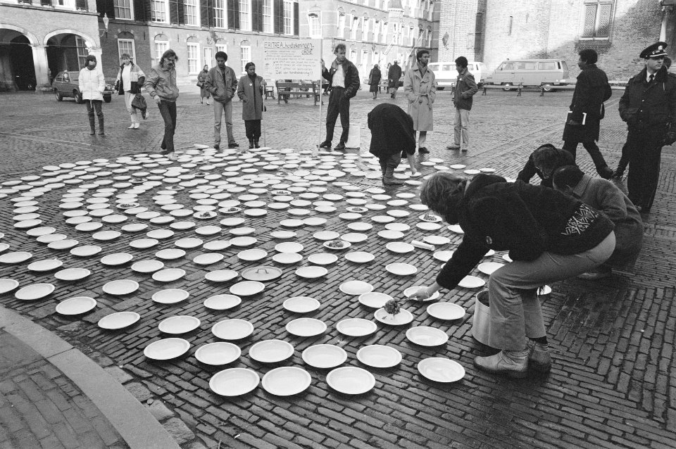 Actie_voor_aandacht_voedselhulp_Eritrea_bordjes_met_eten_op_het_Binnenhof,_Bestanddeelnr_933-2200