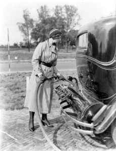 Actrice_en_fotomodel_Cissy_van_Bennekom_met_benzineslang_in_de_handen_bij_benzin,_Bestanddeelnr_252-0487