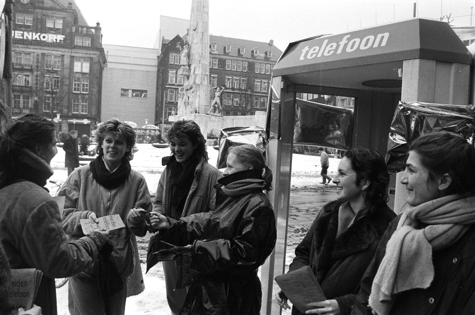 Actievoerende medewerksters van de meidentelefoon delen folders uit op de Dam, Bestanddeelnr 933-5252