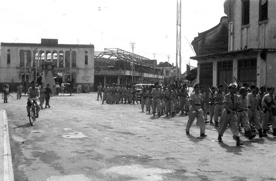 Afdeling 'geregelde TNI--militairen marcheren de stad in. In de achtergrond ruÍ, Bestanddeelnr 892