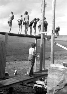 Alafoss Groep jonge meisjes op een duikplank in een openluchtzwembad Beneden s, Bestanddeelnr 190-0333