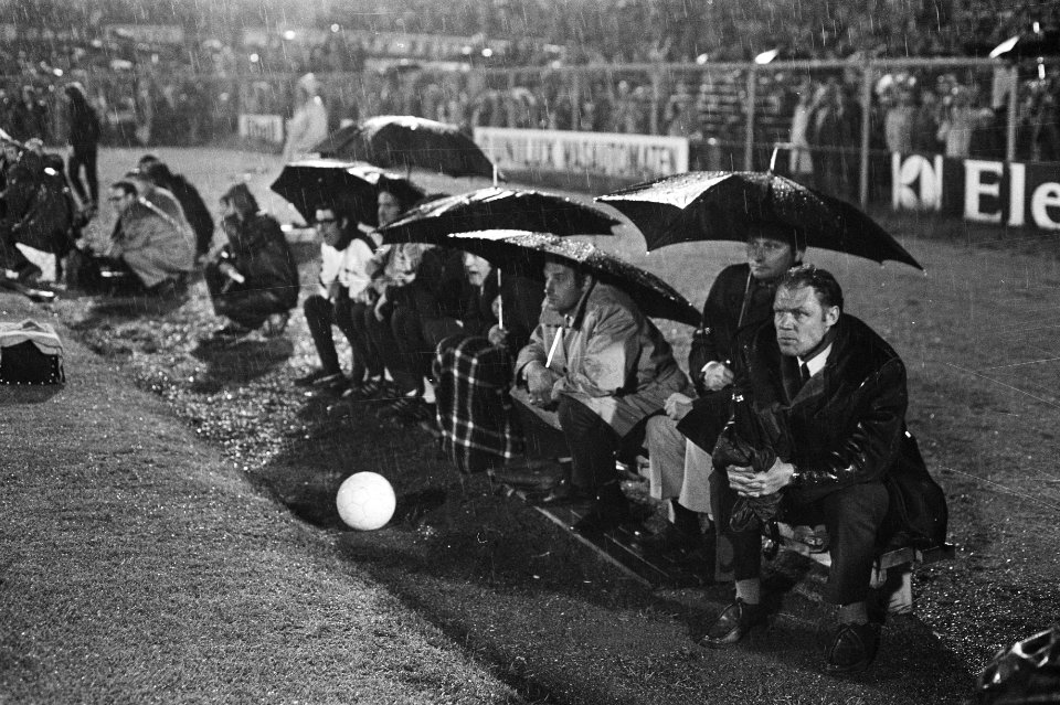 Ajax-Feyenoord 1-3. Spelers met paraplu's op de reservebank, rechts Ajax-traine…, Bestanddeelnr 924-5913