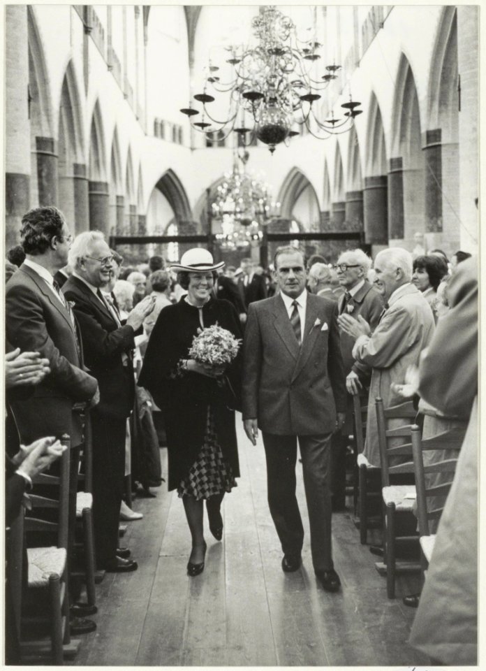 Aankomst in de Grote of St. Bavokerk van Koningin Beatrix en Prins Claus. Naast de Koningin president-kerkvoogd Vermaire. Het bezoek vond plaats i.v.m. de opening van de kerk na de restaurat, NL-HlmNHA 54002624