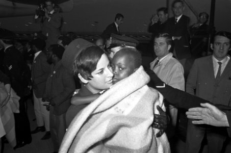 Aankomst van 5 kinderen uit Biafra op Schiphol een stewardes draagt een van de k, Bestanddeelnr 921-7496