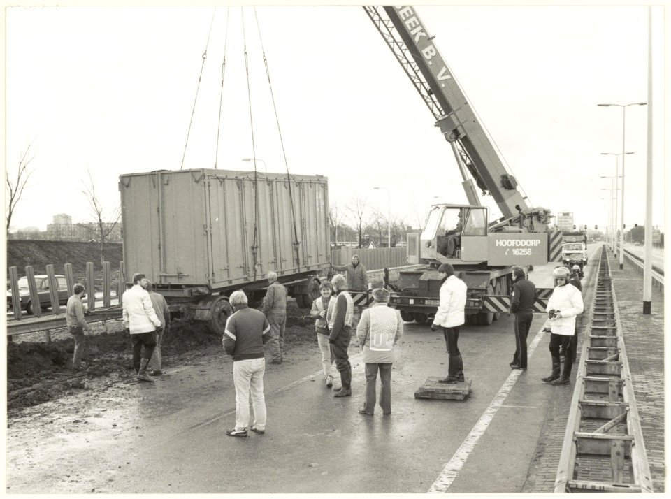 Aanhanger van een duitse vrachtwagencombinatie wordt uit de modder getakeld. Amsterdamse Vaart, ter hoogte van het huidige station Spaarnwoude. NL-HlmNHA 54023314