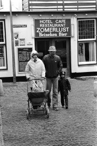 Aanhoudend slecht weer in Nederland vakantiegangers lope door de stromende regen in Zandvoort, op de achtergrond hotel Zomerlust, Bestanddeelnr 931-5696