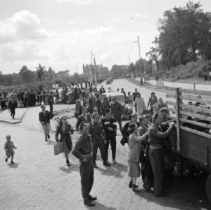 Aan de rand van de stad bestormen burgers een vrachtwagen bij een uitvalsweg R, Bestanddeelnr 900-6223
