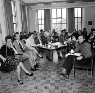 Aan de tafel achter de bloemen mr. H.J.P. van de Meerendonk (directeur) (met zwa, Bestanddeelnr 927-9024