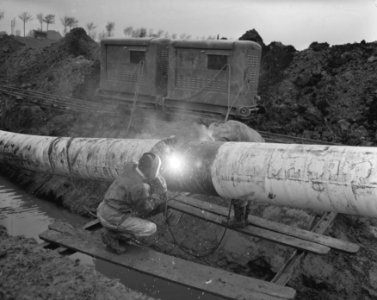 Aanleg Rotterdam Rijn oliepijpleiding ten zuiden van Rhoon, lassers lassen stuk , Bestanddeelnr 909-9633