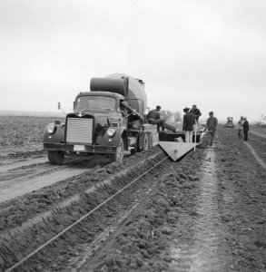 Aanleg en verbeteren van wegen, dijken en spaarbekken, arbeiders, aanbrengen bet, Bestanddeelnr 161-1033