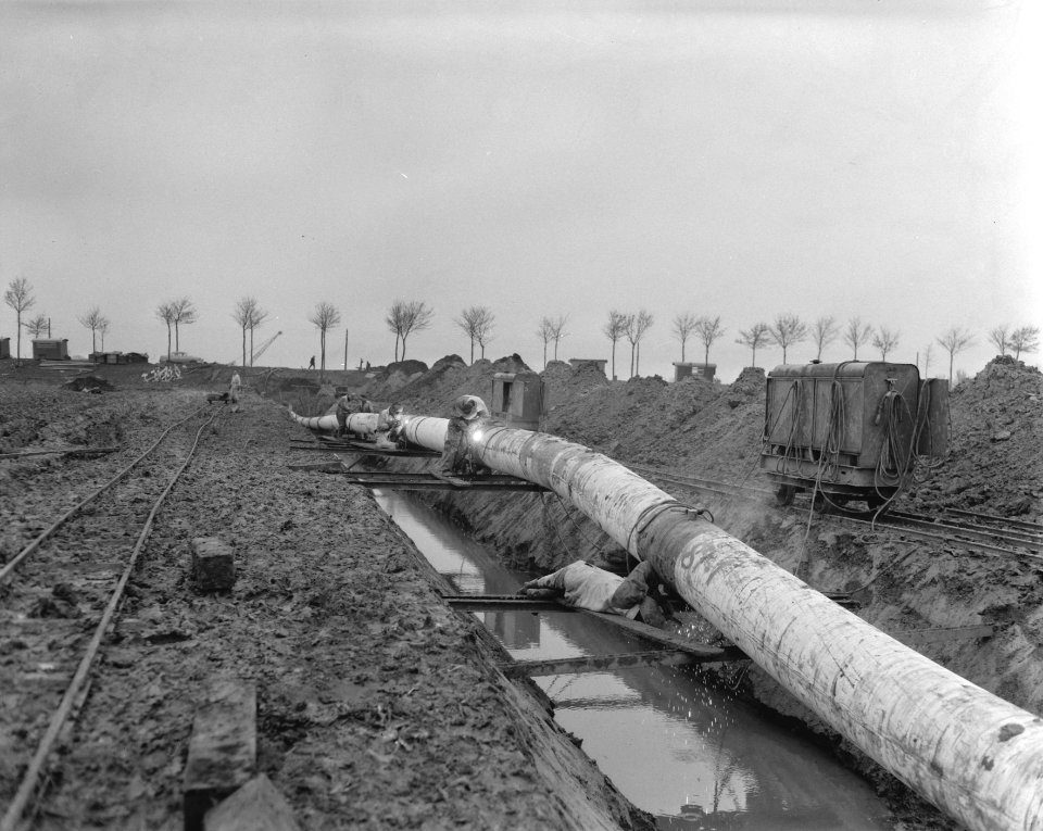Aanleg Rotterdam Rijn oliepijpleiding ten zuiden van Rhoon, lassers lassen stuk , Bestanddeelnr 909-9634