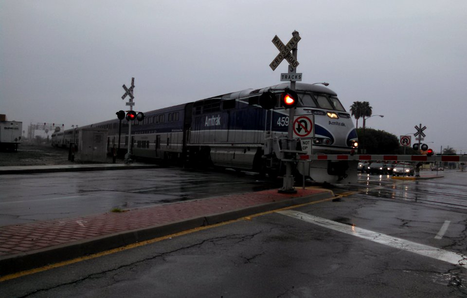 Amtrak train passing Santa Fe Springs California on BNSF tracks on rainy day