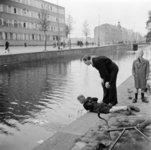 Amsterdam. Bevrijding. Straatbeelden Man en jongen kijken in het water van een , Bestanddeelnr 900-3171