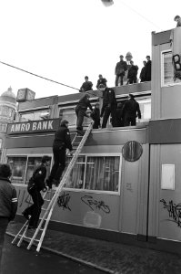 Amsterdammers tegen apartheid bezetten het dak van het noodgebouw van de Amroban, Bestanddeelnr 933-1739