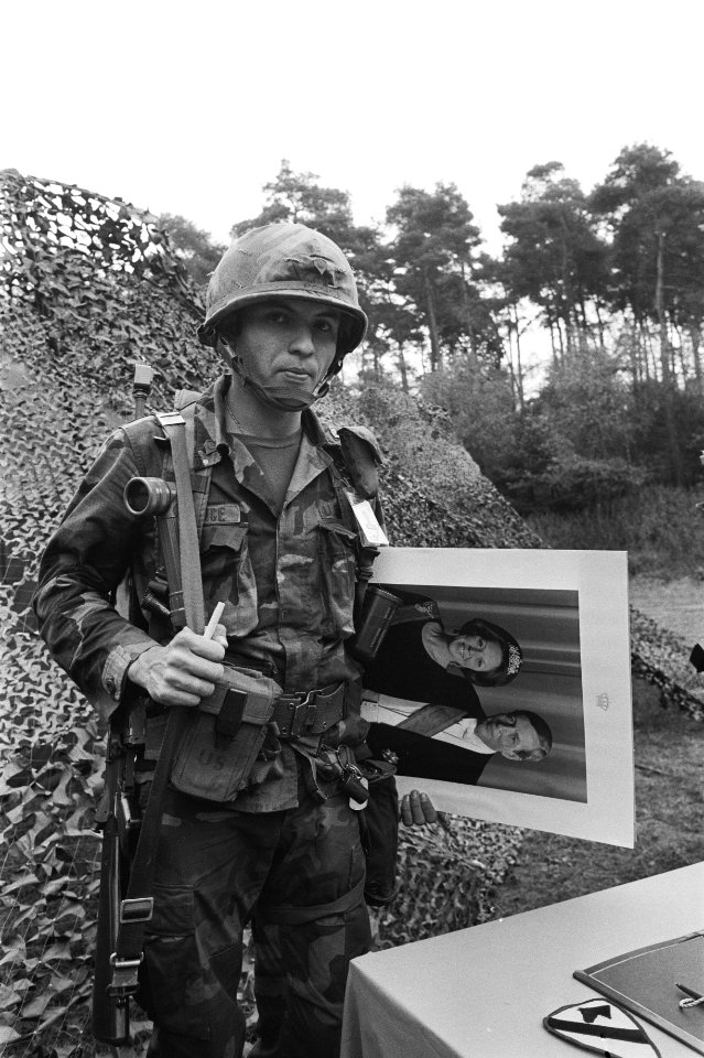 Amerikaanse militair met een staatsieportret van koningin Beatrix en prins Claus, Bestanddeelnr 932-7086