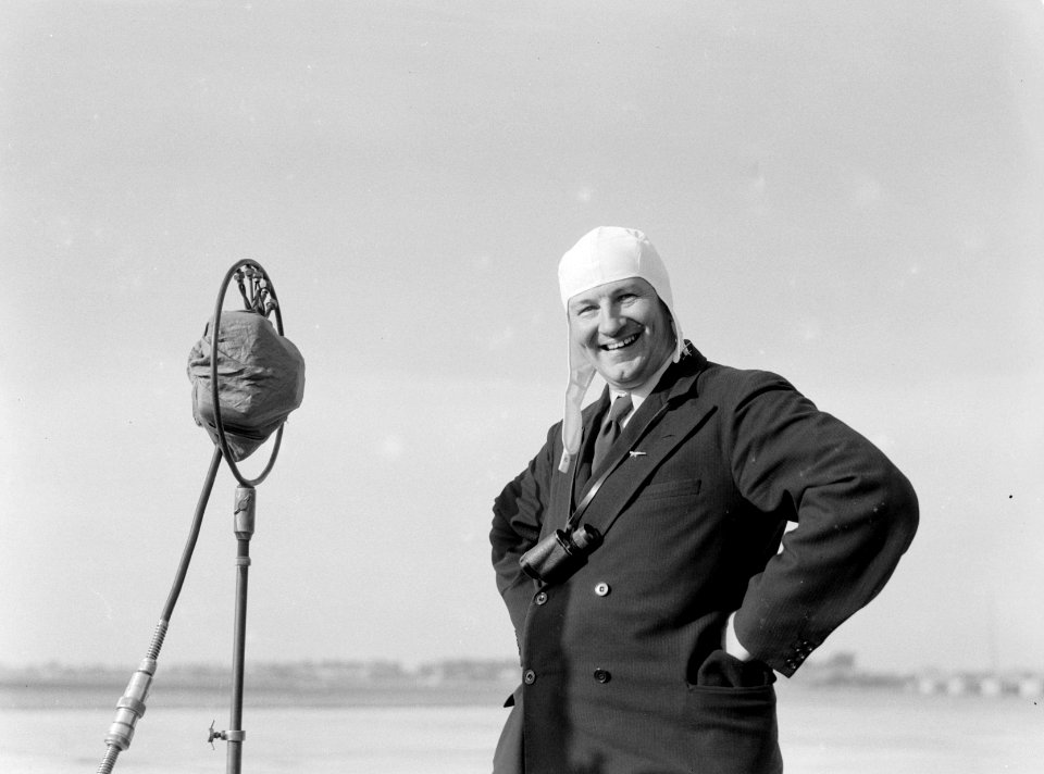Anthony Fokker met vliegenierskap en verrekijker bij microfoon op luchthaven Sch, Bestanddeelnr 190-0078