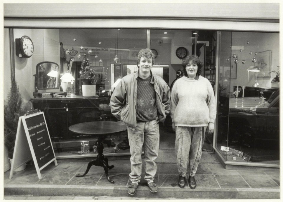 Antiekrestaurateurs Menno en Willeke van den Bos voor hun winkel aan de Spaarnwouderstraat 63. NL-HlmNHA 54020749
