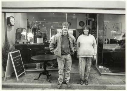 Antiekrestaurateurs Menno en Willeke van den Bos voor hun winkel aan de Spaarnwouderstraat 63. NL-HlmNHA 54020749