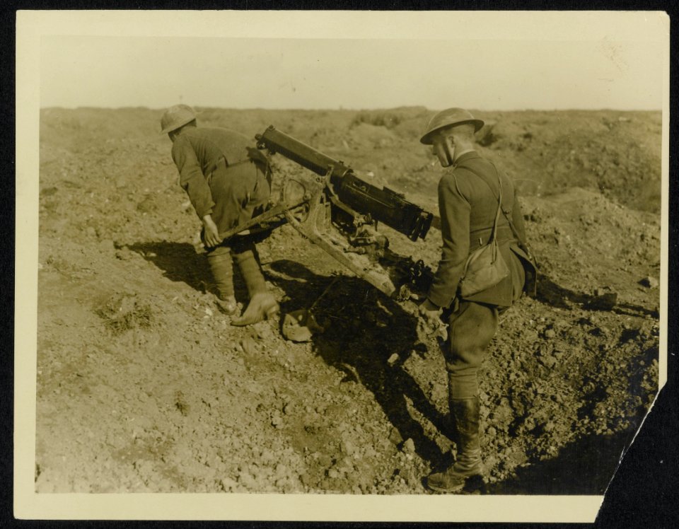 An officer and his man of the M.G. Corps carrying a German gun into position to , Bestanddeelnr 158-0752