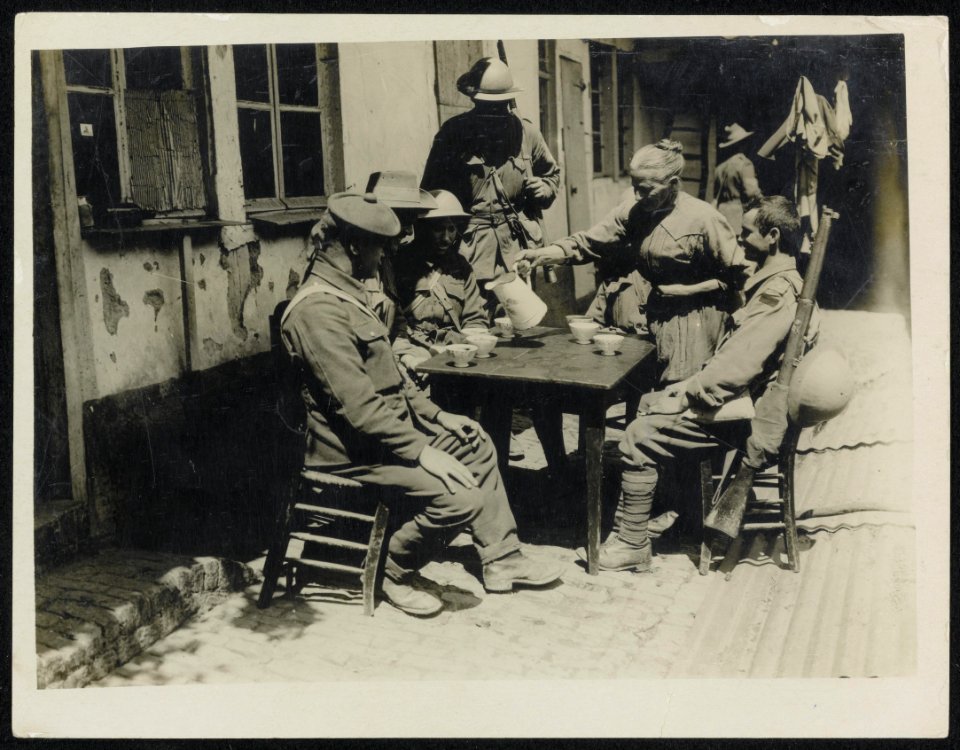 An old French woman giving some soldiers coffee. The scene is within 800 yards o, Bestanddeelnr 158-1393