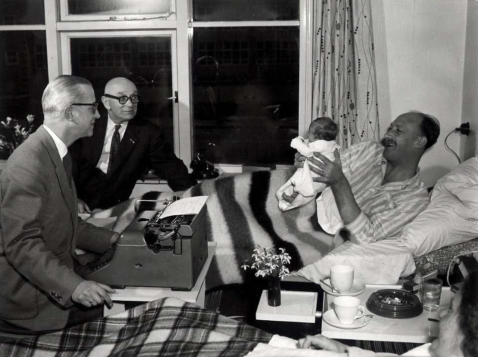 Als de vader ook ziek is, geschiedt de aangifte van een pasgeboren baby, bij de burgerlijke stand, ook wel thuis. Aangekocht in 1977 van fotograaf C. de Boer. Categorie 81-11 Identificatienu, NL-HlmNHA 54010752