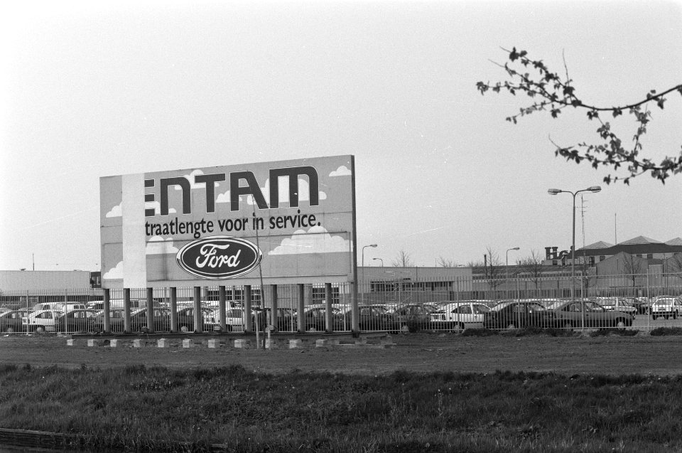 Autos op parkeerplaatsen met reclamebord van ford, Bestanddeelnr 934-2373