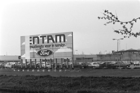 Autos op parkeerplaatsen met reclamebord van ford, Bestanddeelnr 934-2373