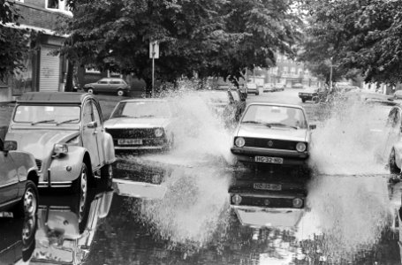 Auto's, waaronder een Lelijke eend hebben last van water na een hevige onweersbu, Bestanddeelnr 932-6710