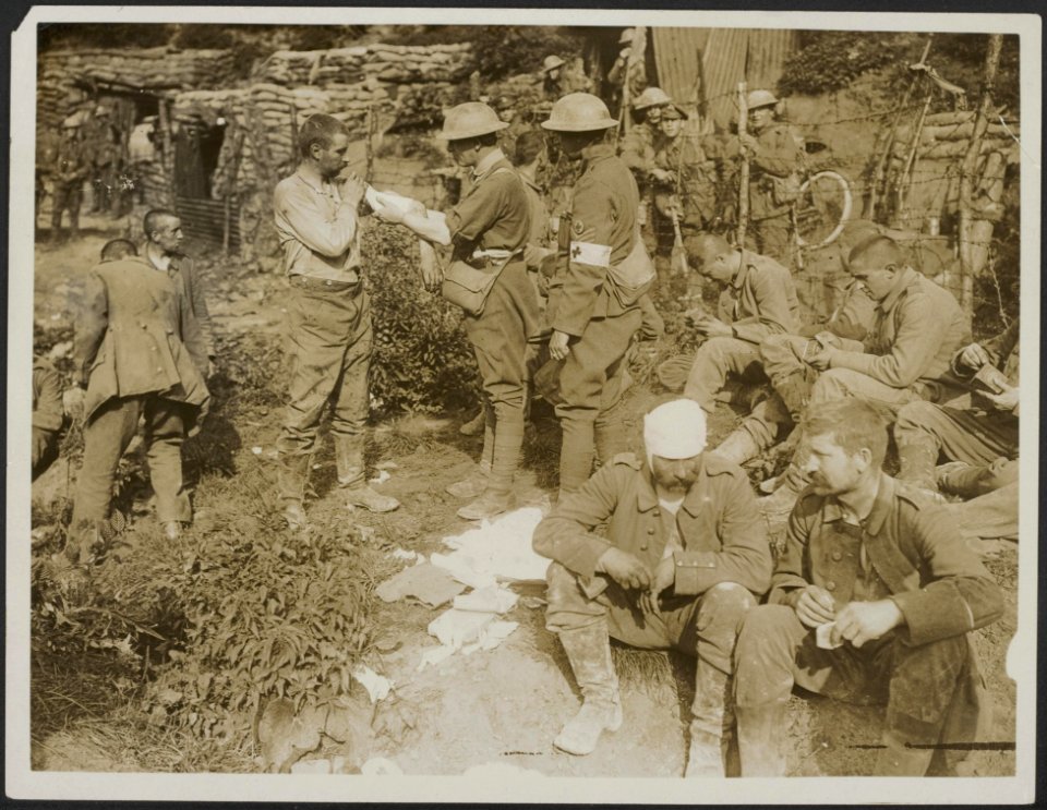 Attending to the German wounded in the prisoners cage., Bestanddeelnr 158-2021
