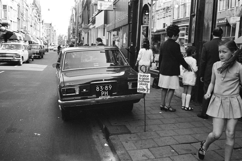 Auto op een stoep in Amsterdam bij een bordje met de tekst troittoir is geen p, Bestanddeelnr 924-5560