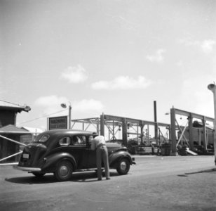 Auto bij de ingang van de Lago-olieraffinaderij in San Nicolas op Aruba, Bestanddeelnr 252-8034