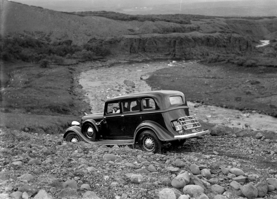 Auto op een smalle weg in een rotsachtig landschap bij een snelstromende beek, Bestanddeelnr 190-0292