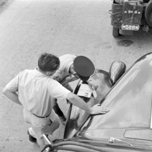 Automobilist tijdens een verkeerscontrole door de verkeerspolitie langs de weg, Bestanddeelnr 255-1216