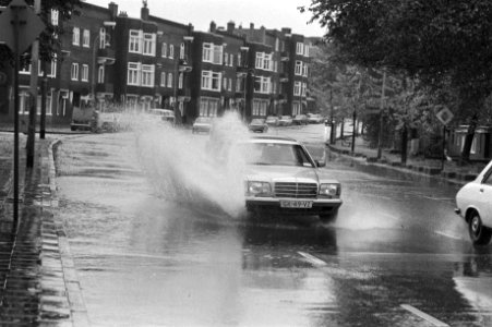 Auto rijdt door een diepe plas na enkele dagen regen, Bestanddeelnr 931-7504