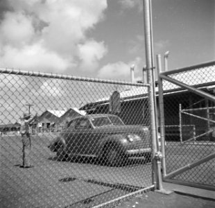 Auto bij de ingang van de Lago-olieraffinaderij in San Nicolas op Aruba, Bestanddeelnr 252-8035