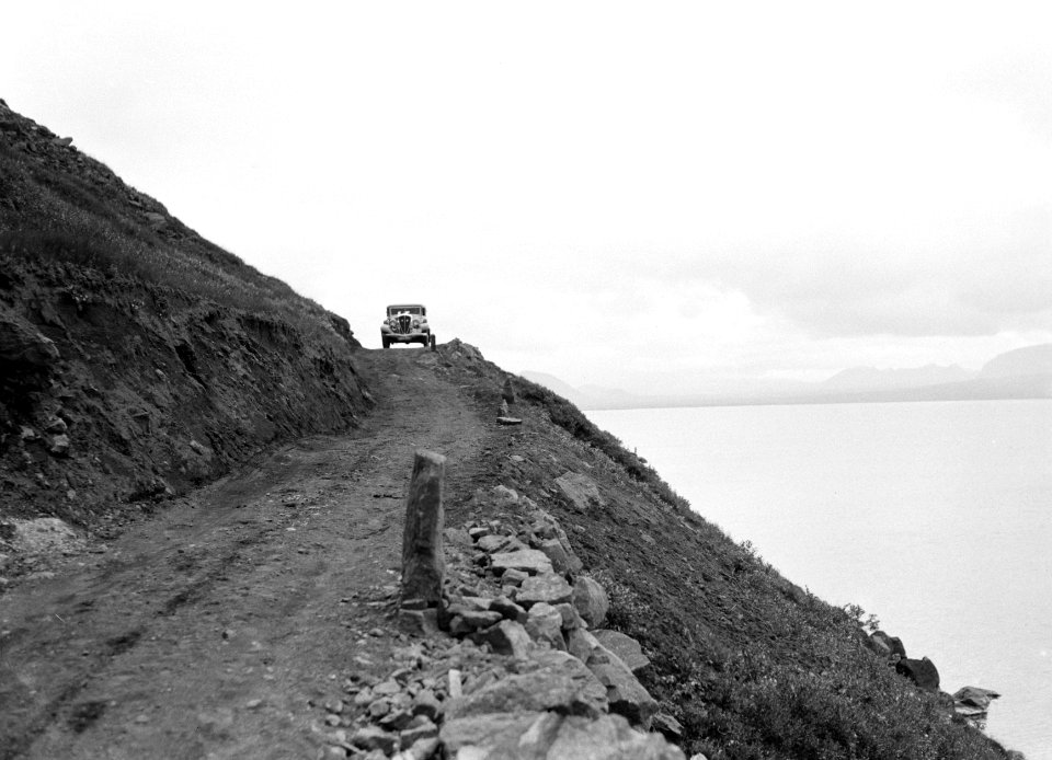 Auto aan het begin van een smalle weg langs de kust met een steile talud, Bestanddeelnr 190-0290