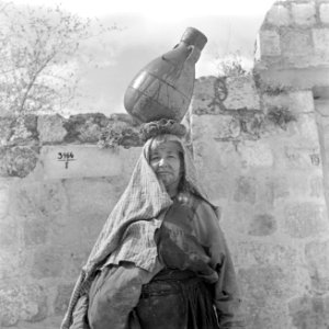 Arabische vrouw met waterkruik op het hoofd bij een muur, Bestanddeelnr 255-1427