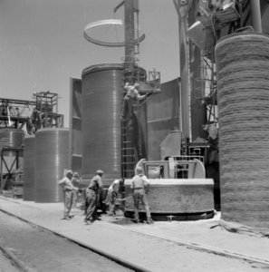 Arbeiders aan het werk bij mallen voor het gieten van betonnen buizen op het ter, Bestanddeelnr 255-4738