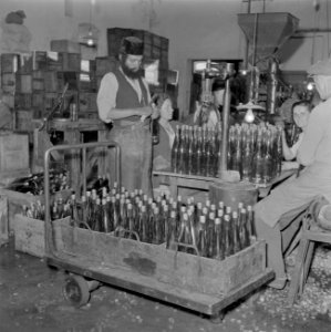 Arbeiders bezig met het kurken van wijnflessen in de Rothschild wijnkelders te R, Bestanddeelnr 255-1607