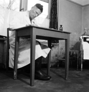 Arts of laborant achter een schrijftafel, Bestanddeelnr 900-7646