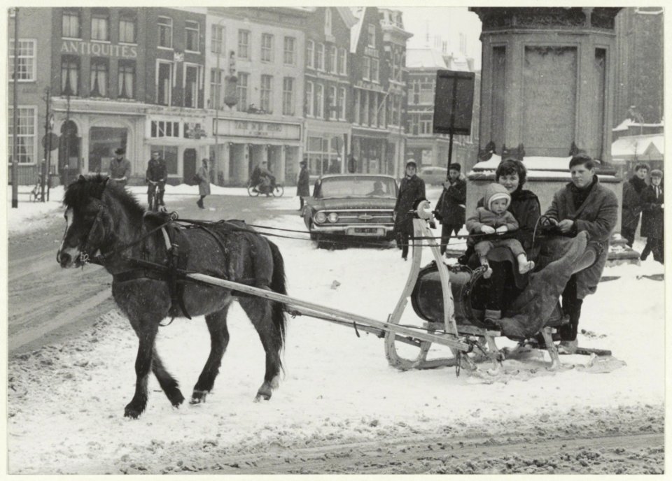 Arreslee met paard in de sneeuw op de Grote Markt bij het standbeeld van L.J. Coster. NL-HlmNHA 54008965