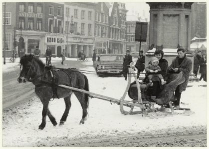 Arreslee met paard in de sneeuw op de Grote Markt bij het standbeeld van L.J. Coster. NL-HlmNHA 54008965