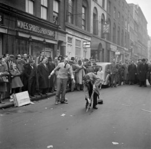 Arthur daagt iemand uit het publiek uit om het kunstje met de stok na te doen, Bestanddeelnr 191-0989