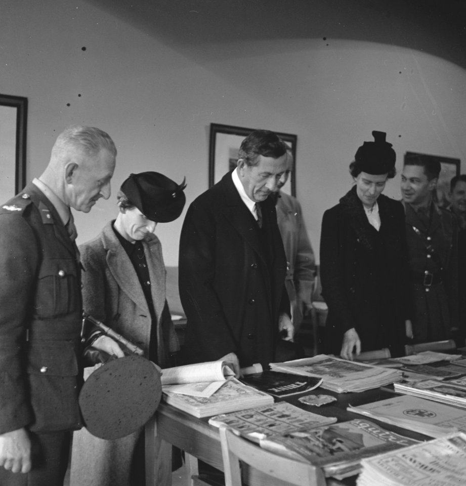 Army 557 Some guests being shown over the library by the camp commander. Kantine, Bestanddeelnr 934-9427