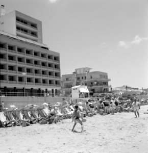 Badgasten en strandstoelen aan de rand van het strand (tegen de flatgebouwen aan, Bestanddeelnr 255-1979
