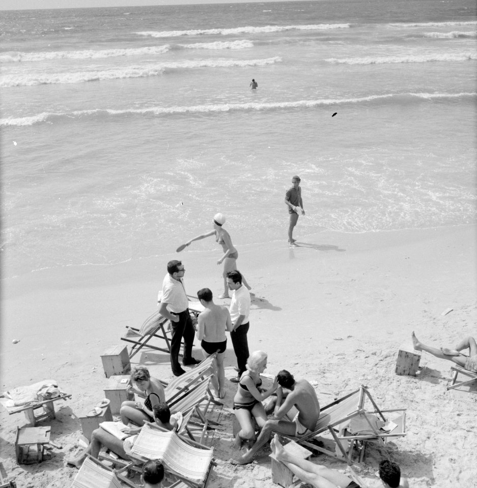 Badgasten en strandstoelen op het strand (in de branding van de zee spelen mense, Bestanddeelnr 255-1949